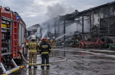 Zdjęcie ilustracyjne: strażacy przy pogorzelisku i wozie strażackim